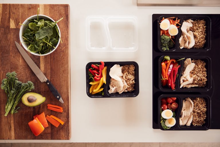 Overhead Shot Of Ingredients And Containers For Batch Of Healthy Meals At Home On Kitchen Counter